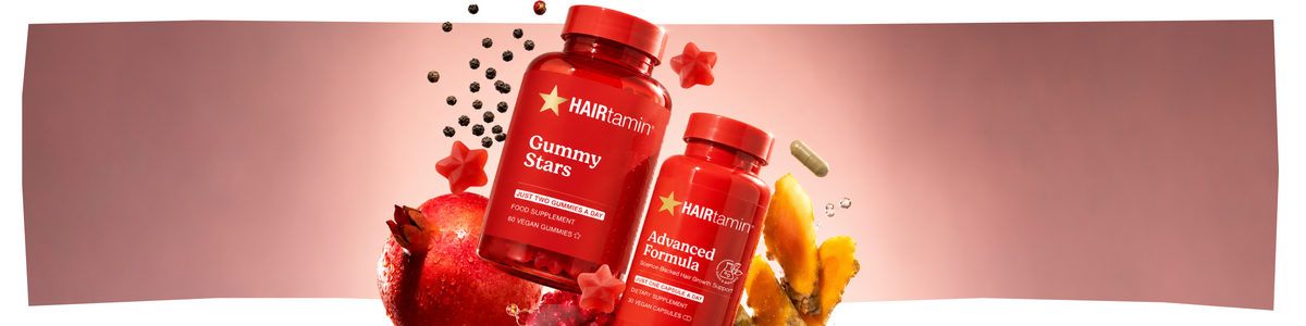 Zwei Flaschen HAIRtamin-Nahrungsergänzungsmittel, Gummy Stars und Advanced Formula, umgeben von Granatapfel, Kurkuma, Pfefferkörnern und sternförmigen Gummibärchen.