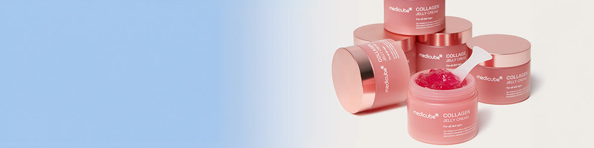 Mehrere rosafarbene Tiegel der Medicube Collagen Jelly Cream, einer geöffnet mit sichtbarer Gel-Textur und Spatel, vor hellem Hintergrund mit blauem Farbverlauf.