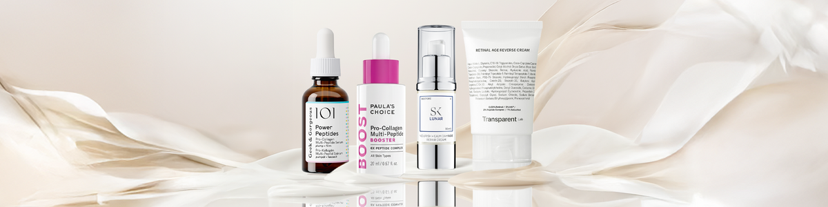 Fünf Serum- und Cremeflaschen und -tuben sind in einer Reihe auf einem weichen, beigefarbenen, wirbelnden Hintergrund angeordnet.