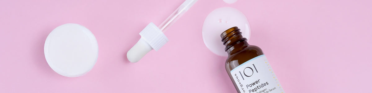 Geöffnetes Serumfläschchen mit Pipette von Geek & Gorgeous liegt auf rosa Hintergrund.