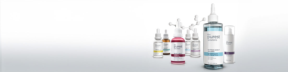 Mehrere Hautpflegeprodukte mit Pipetten- und Spenderflaschen der Marke ‚The Purest Solutions‘ stehen auf weißem Untergrund.