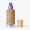 Eine Flasche Skin Realist Tinted Balm in der Farbe 4 Medium-Tan mit einem violetten Pumpspender und einem goldenen Deckel daneben.