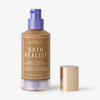 Eine Flasche Skin Realist Tinted Balm in der Farbe 5 Tan mit einem violetten Pumpspender und einem goldenen Deckel daneben.