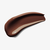 Ein glatter Fleck Skin Realist Tinted Balm in der Farbe 7 Deep auf weißem Hintergrund.