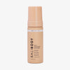 Eine pfirsichfarbene Flasche Self Tanning Mousse 100 ml Dark vor weißem Hintergrund.