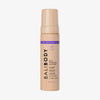 Eine pfirsichfarbene Flasche Bali Body Self Tanning Mousse Deep Violet vor weißem Hintergrund.