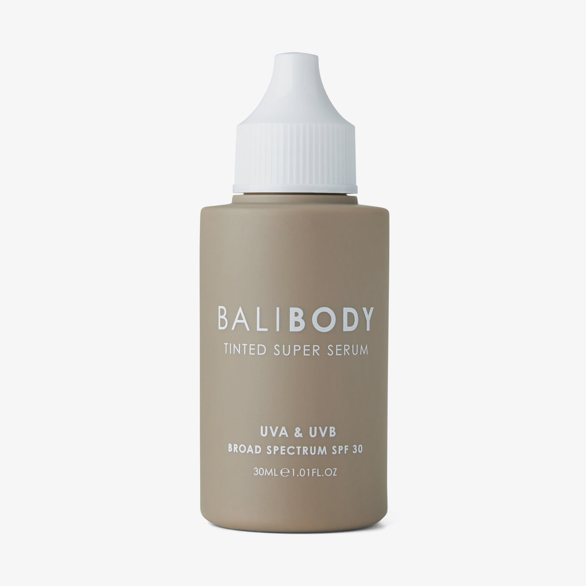 Eine hellbraune Flasche Tinted Super Serum SPF 30 von Bali Body mit weißem Deckel vor weißem Hintergrund
