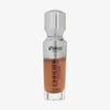 Eine halb transparente halb silberne Flasche Chroma Cover Foundation Luminous in der Farbe C10 vor weißem Hintergrund.