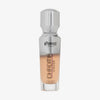 Eine halb transparente halb silberne Flasche Chroma Cover Foundation Luminous in der Farbe C7 vor weißem Hintergrund. 