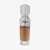 Eine halb transparente halb silberne Flasche Chroma Cover Foundation Luminous in der Farbe C9 vor weißem Hintergrund.
