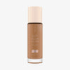 Eine Glasflasche Soft Glam Filter Fluid 065 von Catrice mit hellrosa Deckel und roséfarbener Schrift vor weißem Hintergrund.