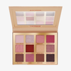 Öffnen Sie die Wonder Woman-Lidschattenpalette mit zwölf Farbtönen in Rosa-, Gold- und Brauntönen, mit einigen geprägten Designs.