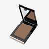 Danessa Myricks Beauty Balm Contour: eine offene Dose mit braunem Puder und verspiegeltem Deckel auf weißem Grund.