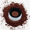 Danessa Myricks Beauty Evolution Powder verteilt sich in einem durchsichtigen Behälter mit schwarzem Deckel, von oben gesehen.