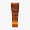 Bronzefarbene Tube der Yummy Skin Serum Tint 12 mit Sichtfenster zum dunkelbraunem Produktinhalt.