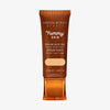 Bronzefarbene Tube der Yummy Skin Serum Tint 2 mit Sichtfenster zum beigen Produktinhalt.