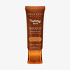 Bronzefarbene Tube der Yummy Skin Serum Foundation 9 mit Sichtfenster zum warmem braunem Produktinhalt.