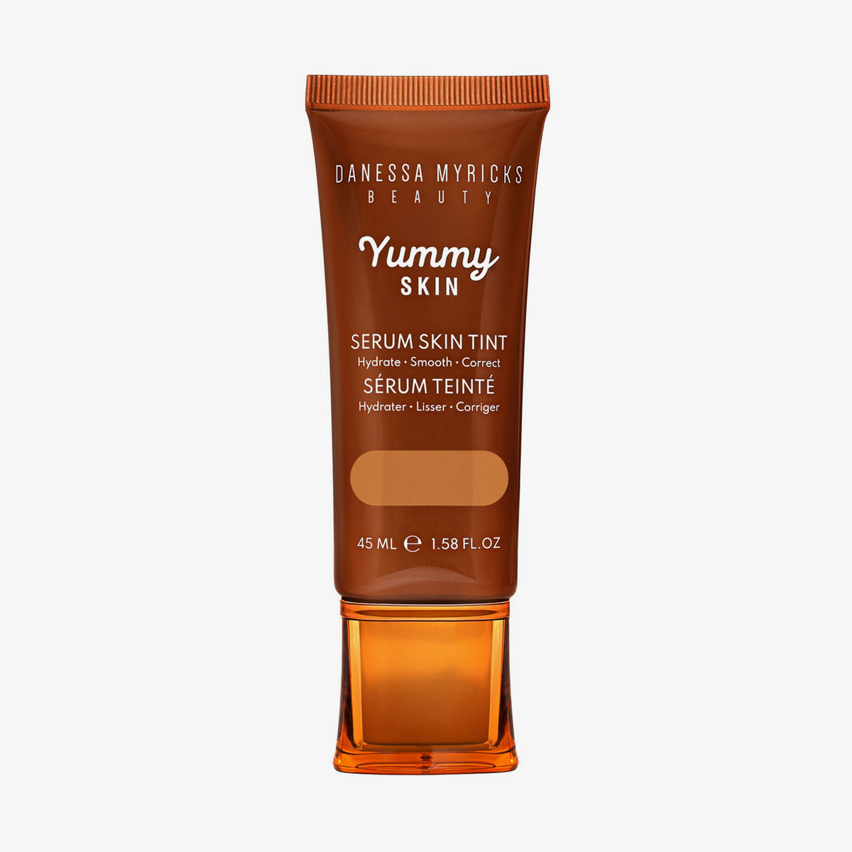 Bronzefarbene Tube der Yummy Skin Serum Foundation 9 mit Sichtfenster zum warmem braunem Produktinhalt.