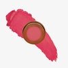 Yummy Skin Blurring Balm Powder Flushed Primadonna in rundem bronzenem Behälter auf tiefpinkem Farbmuster abgebildet.