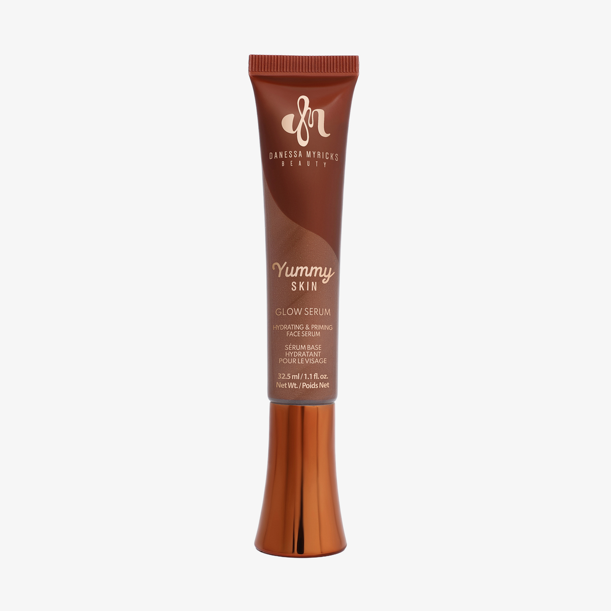 Eine bronzefarbene Tube Yummy Skin Glow Serum Juice Boost vor weißem Hintergrund.