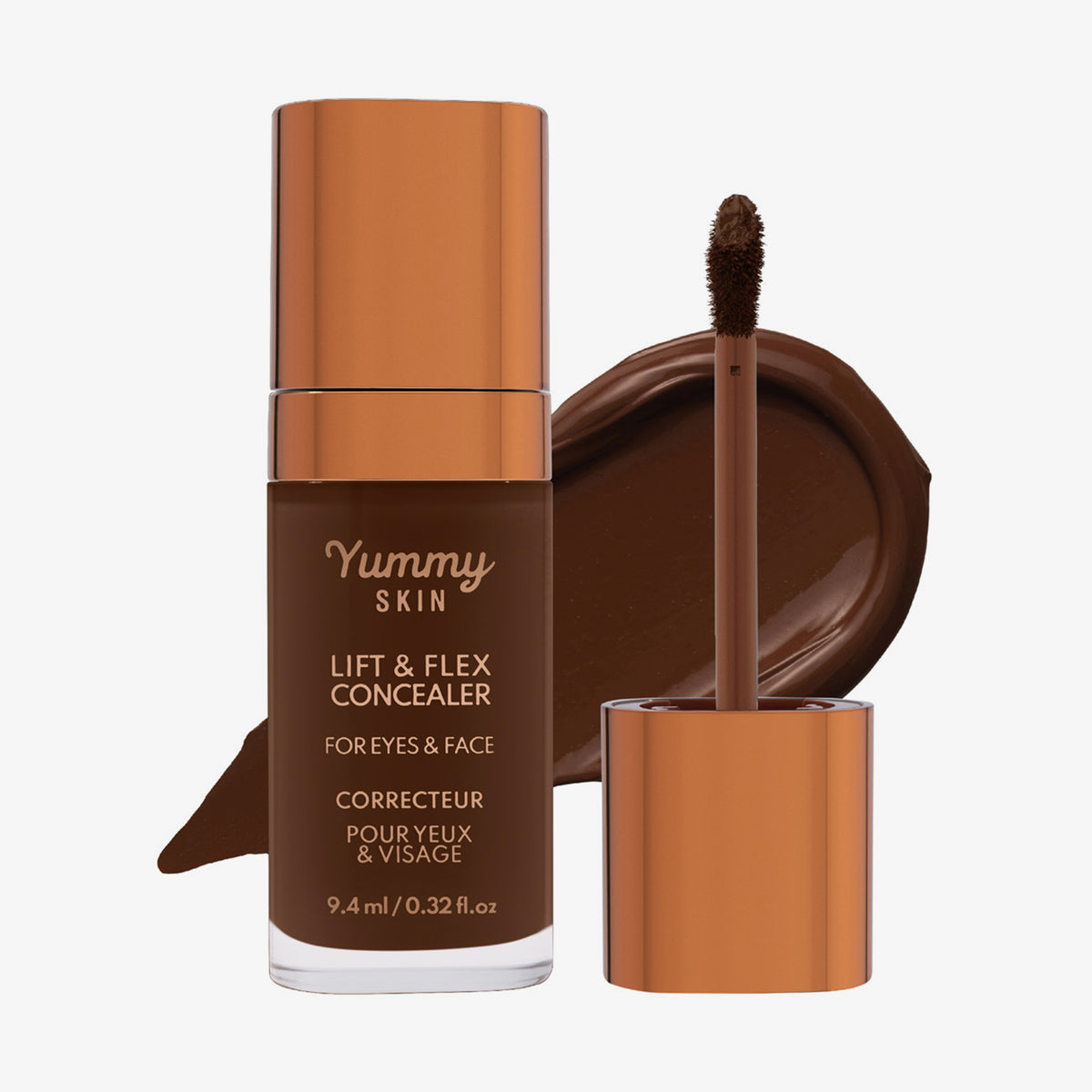 Eine transparente Flasche Yummy Skin Lift & Flex Concealer 19 neben einem bronzenen Applikator vor tiefbraunem Farbmuster.