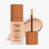 Eine transparente Flasche Yummy Skin Lift & Flex Concealer 5 neben einem bronzenen Applikator vor rosa-beigem Farbmuster.