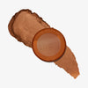 Yummy Skin Blurring Balm Powder Lowlighter Incognito mit cremigem schimmerndem braunem Swatch auf weißem Hintergrund