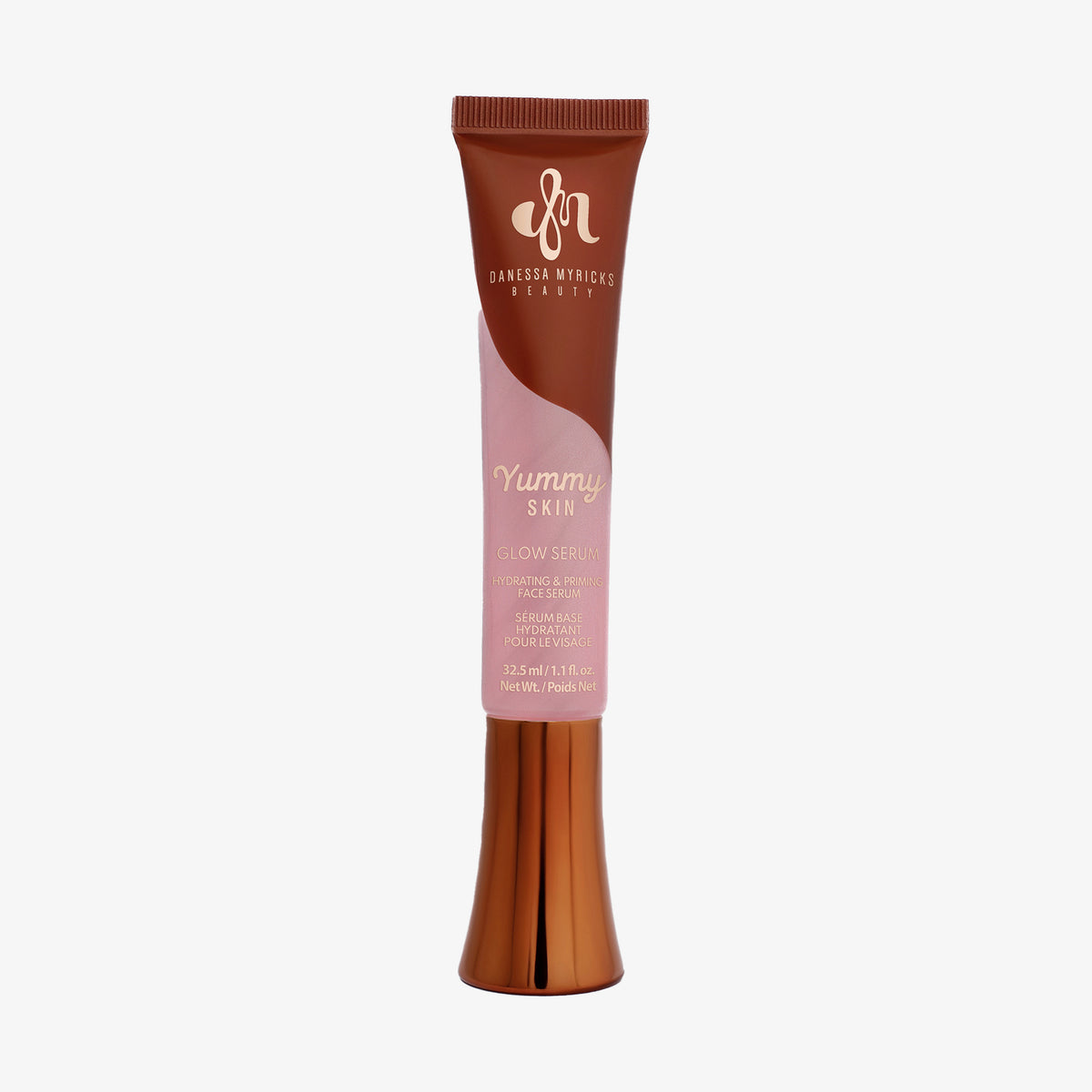 Eine rosa und bronzefarbene Tube Yummy Skin Glow Serum Fresh Pressed vor weißem Hintergrund.
