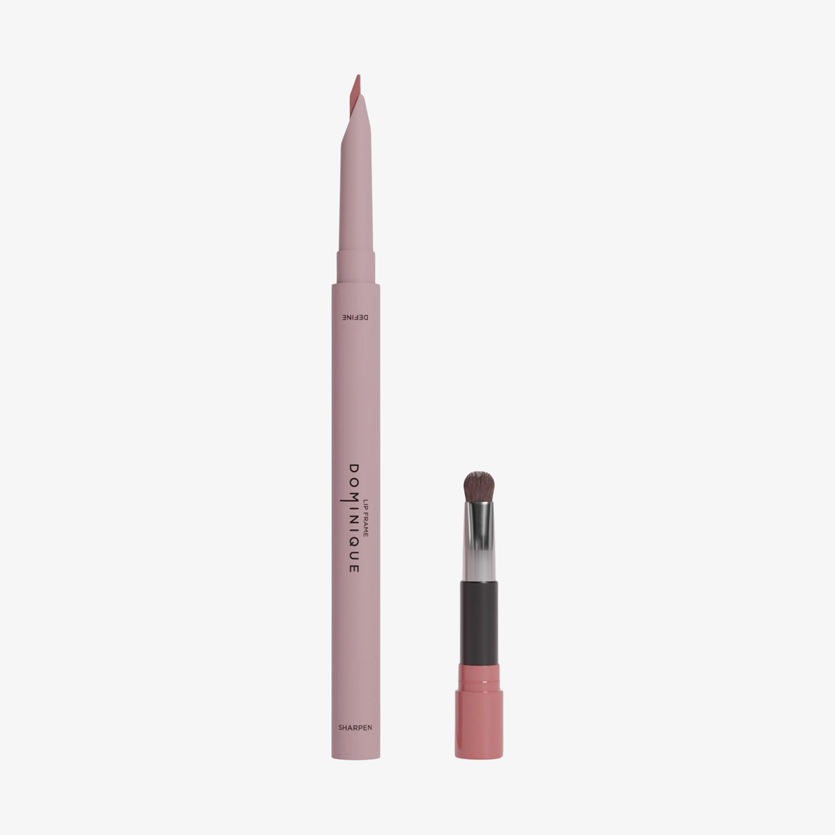 Der Dominique Cosmetics Lip Frame Pencil in der Farbe I'm Blushing und der zugehörige Pinselapplikator vor weißen Hintergrund.