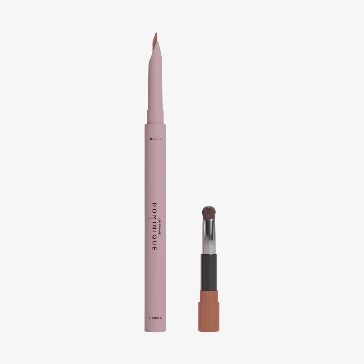 Der Dominique Cosmetics Lip Frame Pencil in der Farbe Toasty Peach und der zugehörige Pinselapplikator vor weißen Hintergrund.