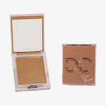 Zwei Silktone Cream Bronzer-Kompaktdosen: eine geöffnete mit dem Creme-Bronzer und integriertem Spiegel und eine geschlossene mit der Aufschrift „Silktone Cream Bronzer“ auf dem Deckel.