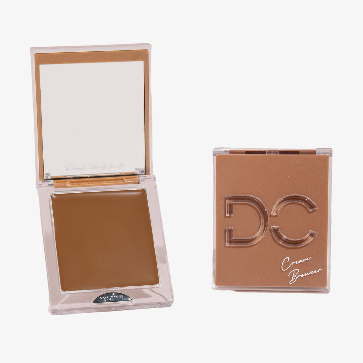 Zwei quadratische Creme-Bronzer-Kompaktdosen – eine geöffnet, um das Produkt freizugeben, eine geschlossene mit der Aufschrift „Silktone Cream Bronzer“ auf dem Deckel.