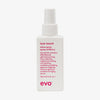 Weiße Flasche Love Touch Shine Spray von Evo mit humorvollem Produkttext vor weißem Hintergrund.
