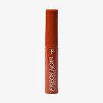 Eine rote Tube mit der Aufschrift Freck Noir von Freck Beauty steht vor einem schlichten weißen Hintergrund.