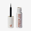 Die weiße Tube mit der Aufschrift Freck OG von Freck Beauty hat eine offene Kappe, in der ein dünner Applikatorpinsel steckt.