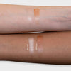 Zwei Arme mit unterschiedlichen Hauttönen zeigen auf jedem Arm Swatches des LH Cosmetics Glowerizer in Me Time und Self Love.