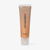 Mattierte beige-orange Tube des LH Cosmetics Glowerizer Self Love vor weißem Hintergrund.