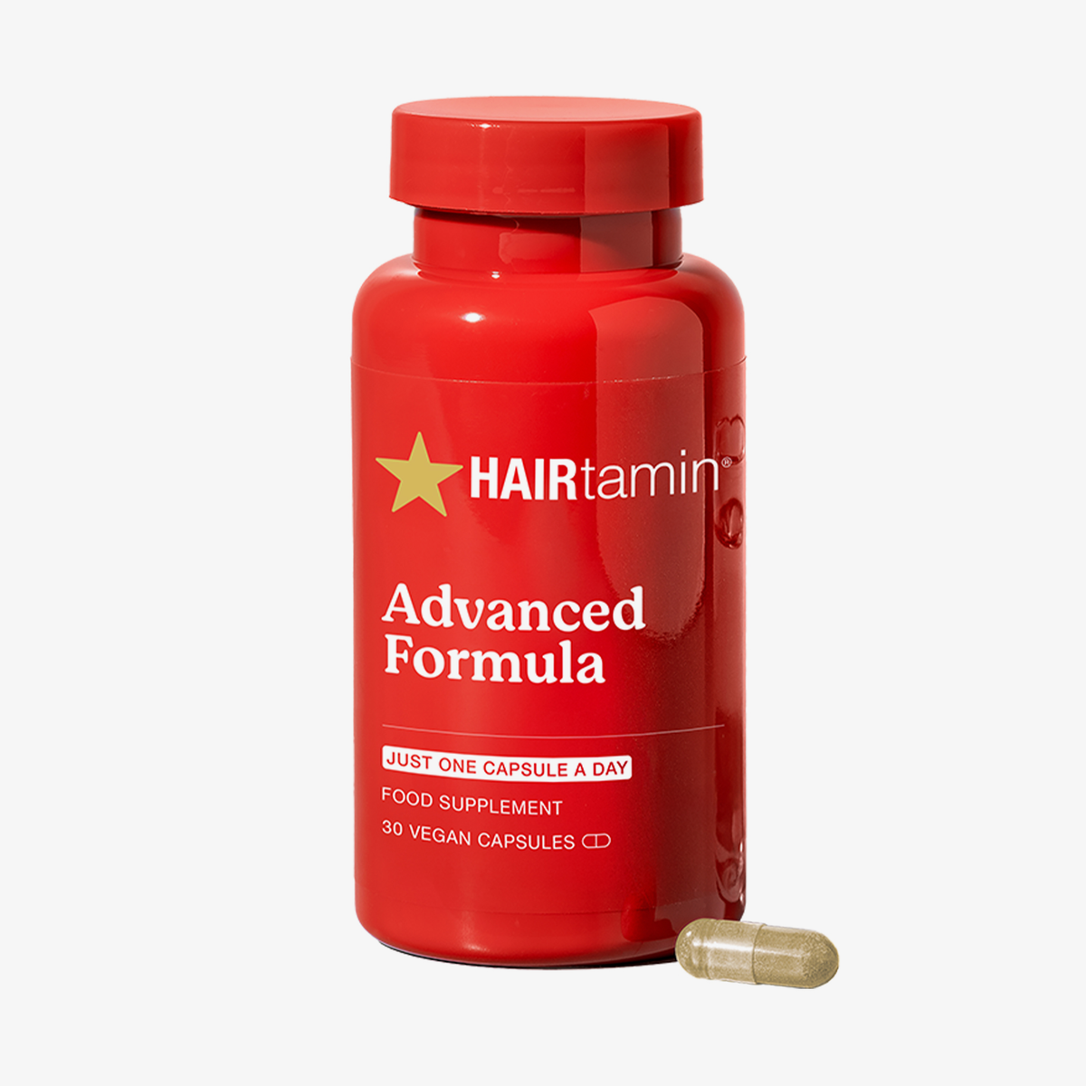 HAIRtamin Advanced Formula – 1-Monats-Packung, veganes Nahrungsergänzungsmittel, 30 Kapseln – eine einzelne Kapsel neben der roten HAIRtamin-Flasche abgebildet.