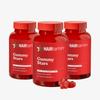 Drei Flaschen HAIRtamin Gummy Stars™ im 3-Monats-Paket mit roten, sternförmigen Gummibonbons im Vordergrund.