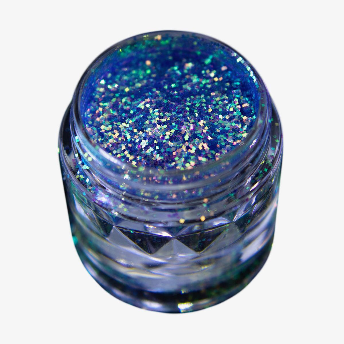 Offener transparenter Tiegel des Glitter Pot Mermaid Fin mit blau-lila schimmerndem Glitzer auf weißem Hintergrund.
