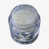 Offener transparenter Tiegel des Glitter Pot Pixie Magic mit Weiß-silber schimmerndem Glitzer auf weißem Hintergrund.