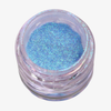 Offener transparenter Tiegel des Opal Multichrome Loose Eyeshadow Dreamer mit blau-türkis schimmerndem Glitzer auf weißem Hintergrund.