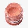 Offener transparenter Tiegel des Pastel Duochromes Loose Eyeshadow Pigtails mit pfirsichfarben schimmernder Textur auf weißem Hintergrund.