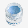 Offener transparenter Tiegel des Pastel Duochromes Loose Eyeshadow Ribbon mit blau schimmernder Textur auf weißem Hintergrund.