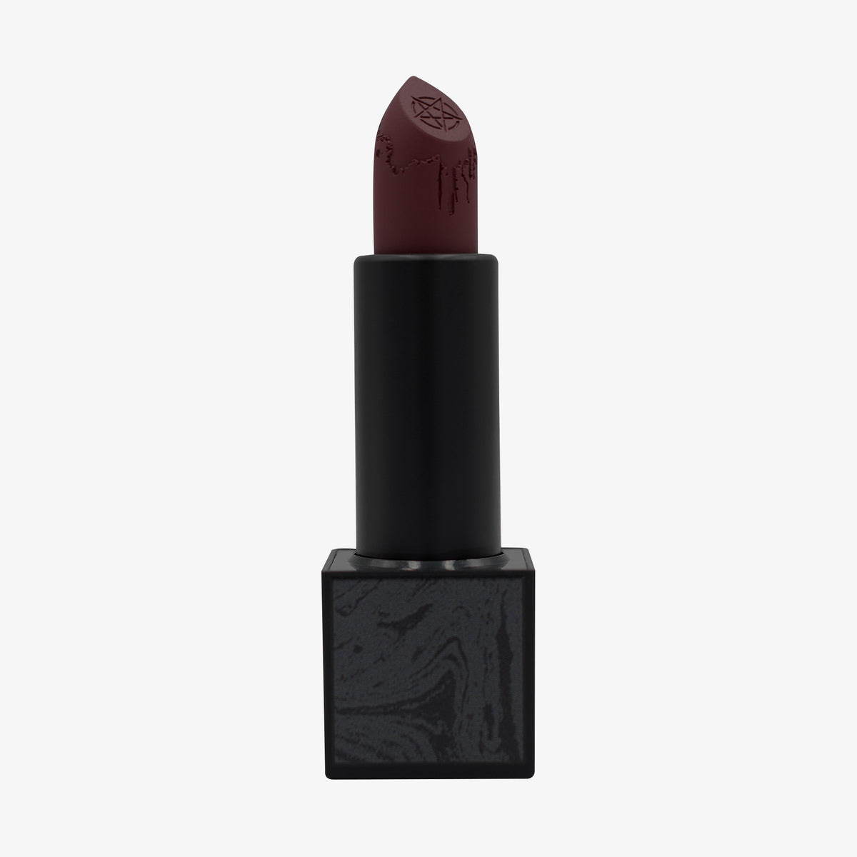 Der „Conjuring Matte Lipstick“ von Lethal Cosmetics: dunkler, kastanienbrauner Farbton, schwarze Hülse, Pentagramm und Tropfengravur an der Lippenstiftspitze.