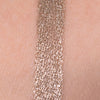 Champagner glitzerndes Muster des Crayon Zhao Flash von LH Cosmetics auf heller Haut.