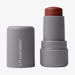 Eine graue Tube LH Cosmetics Artistick Blush in Abstract mit abgenommener Kappe, die den rötlich-braunen Rouge-Stift enthüllt.