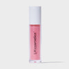 Eine transparente Tube Glazed Drip von LH Cosmetics mit weißem Deckel und rosa glitzerndem Inhalt vor weißem Hintergrund.