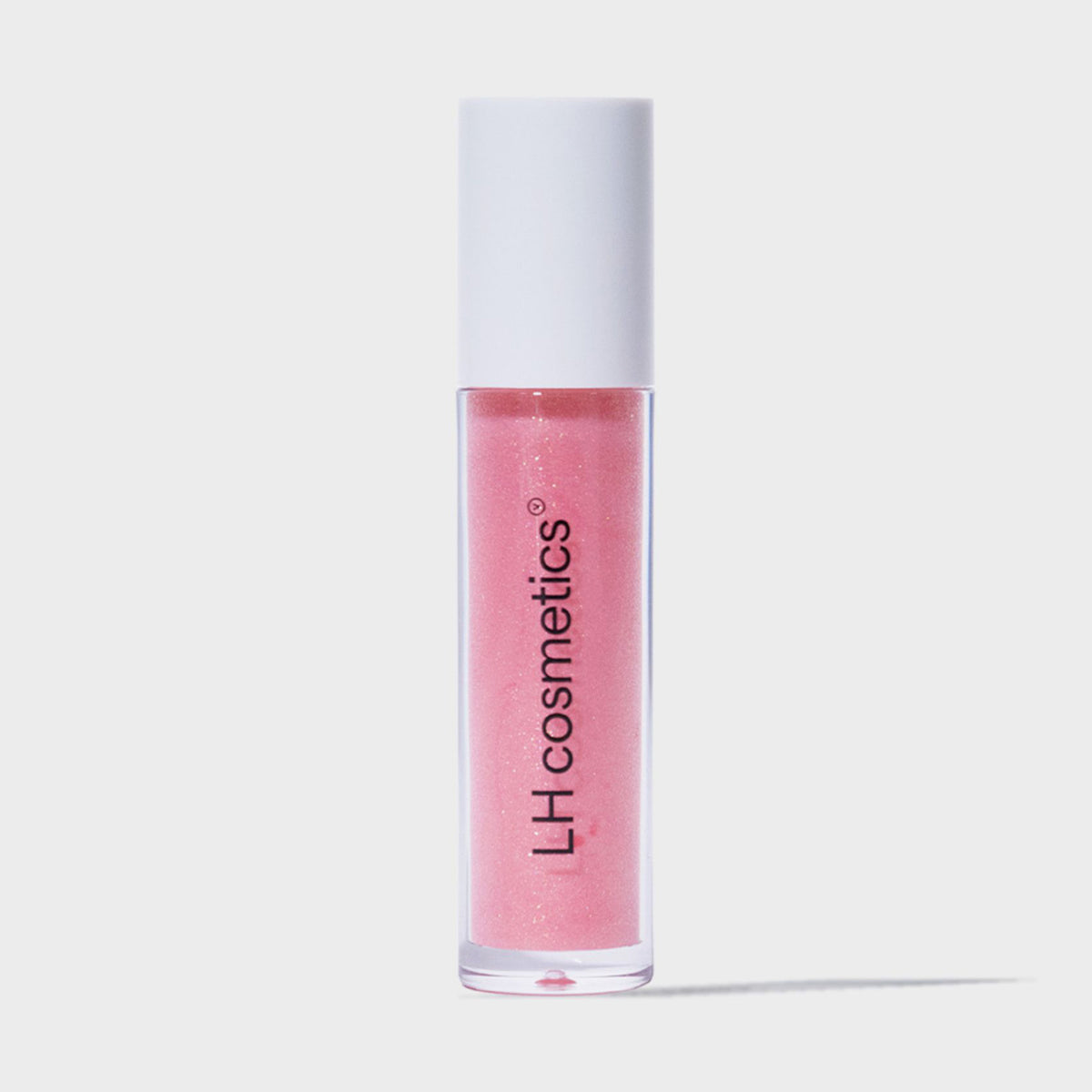 Eine transparente Tube Glazed Drip von LH Cosmetics mit weißem Deckel und rosa glitzerndem Inhalt vor weißem Hintergrund.