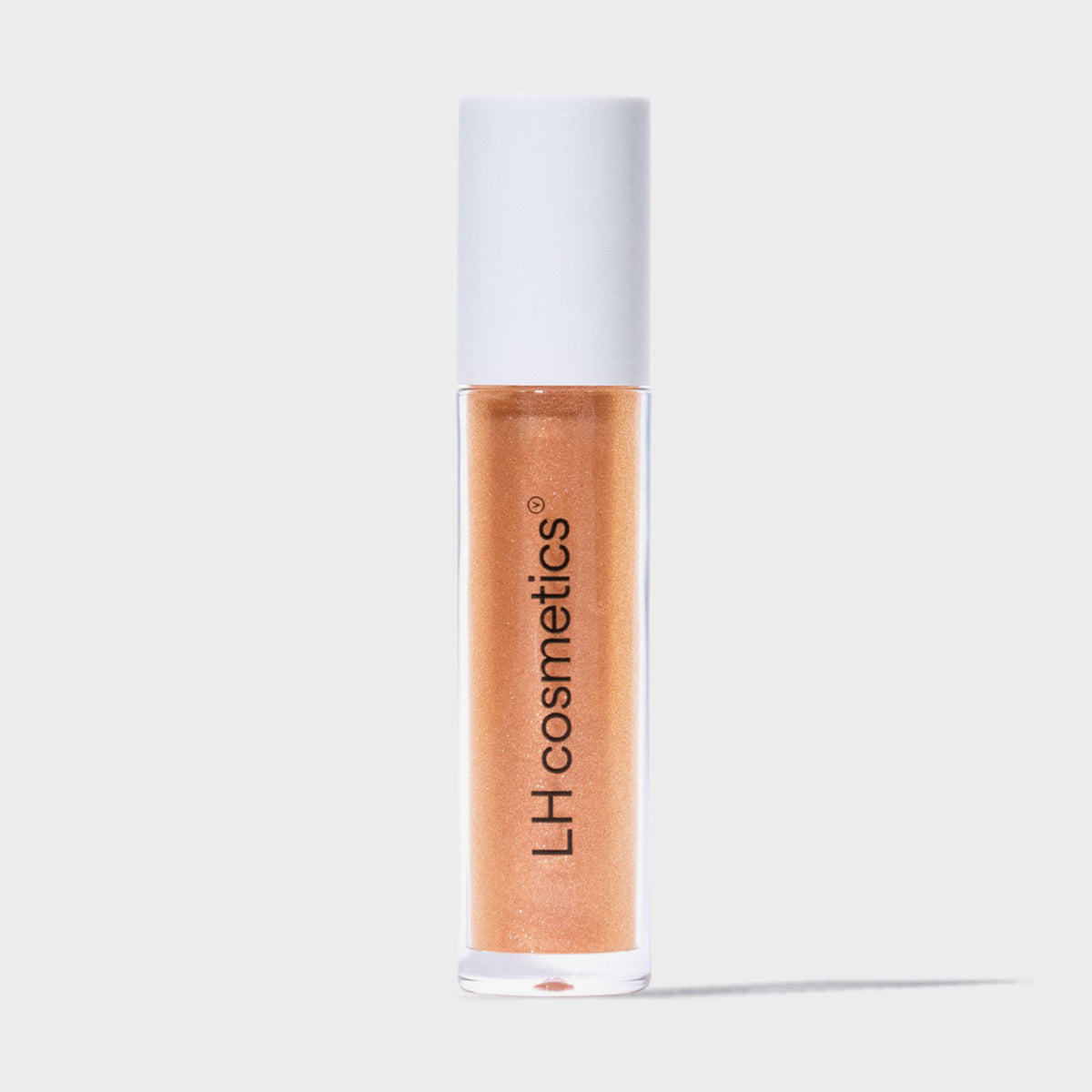 Eine transparente Tube Glazed Melt von LH Cosmetics mit weißem Deckel und orange glitzerndem Inhalt vor weißem Hintergrund.